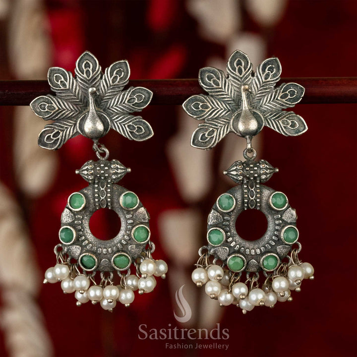 Traditional green gem oxidised earrings featuring peacock feather engraving and soft pearl dangles – echoing the cultural richness of classic jewellery – Sasitrends