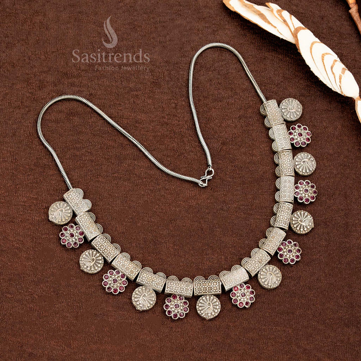 Traditional ruby necklace set in oxidised German silver adorned with floral hanging accents, bold block patterns, and elegant coin studs – a heritage-inspired saree jewellery set by Sasitrends