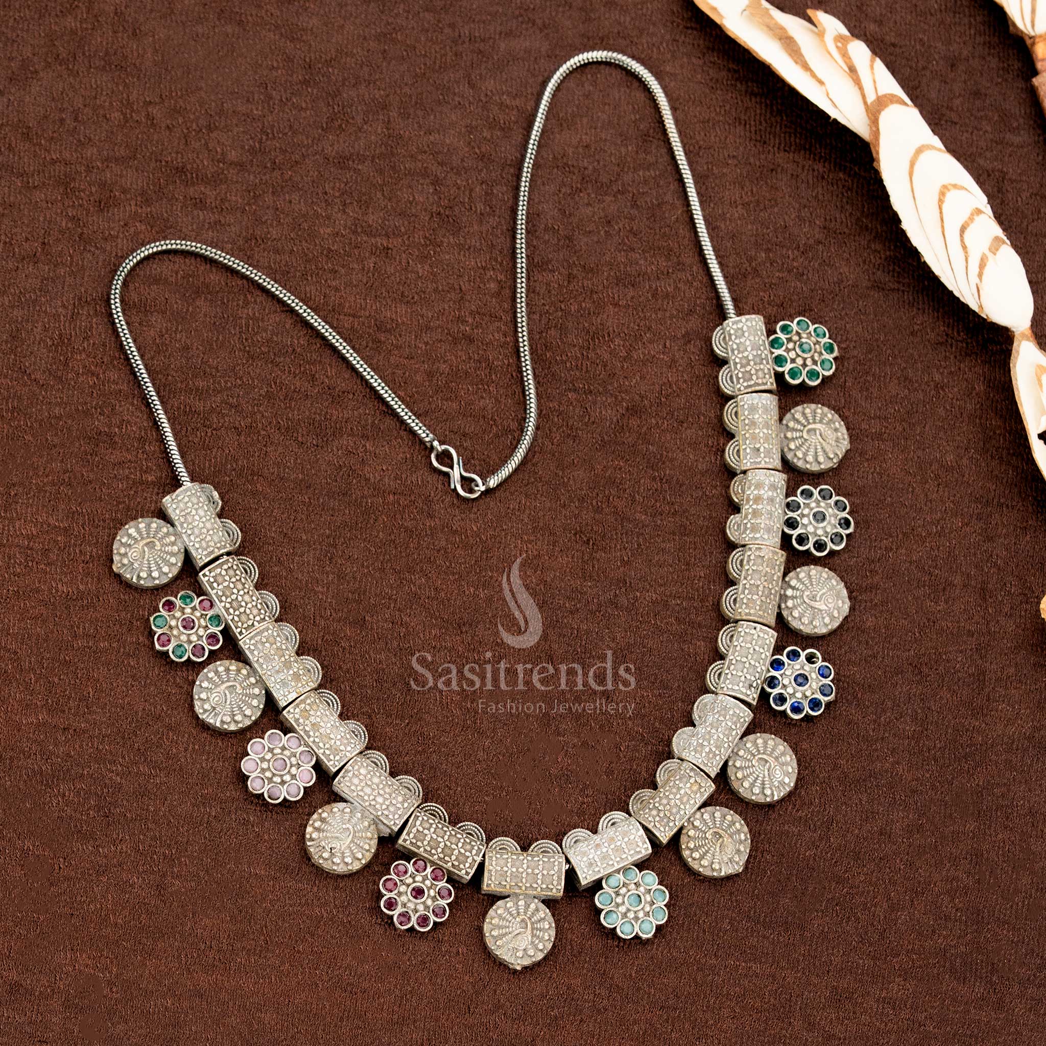 Multi-stone oxidised German silver necklace set with colourful floral hangings, antique block segments, and round studded coin motifs – a vibrant saree jewellery creation by Sasitrends