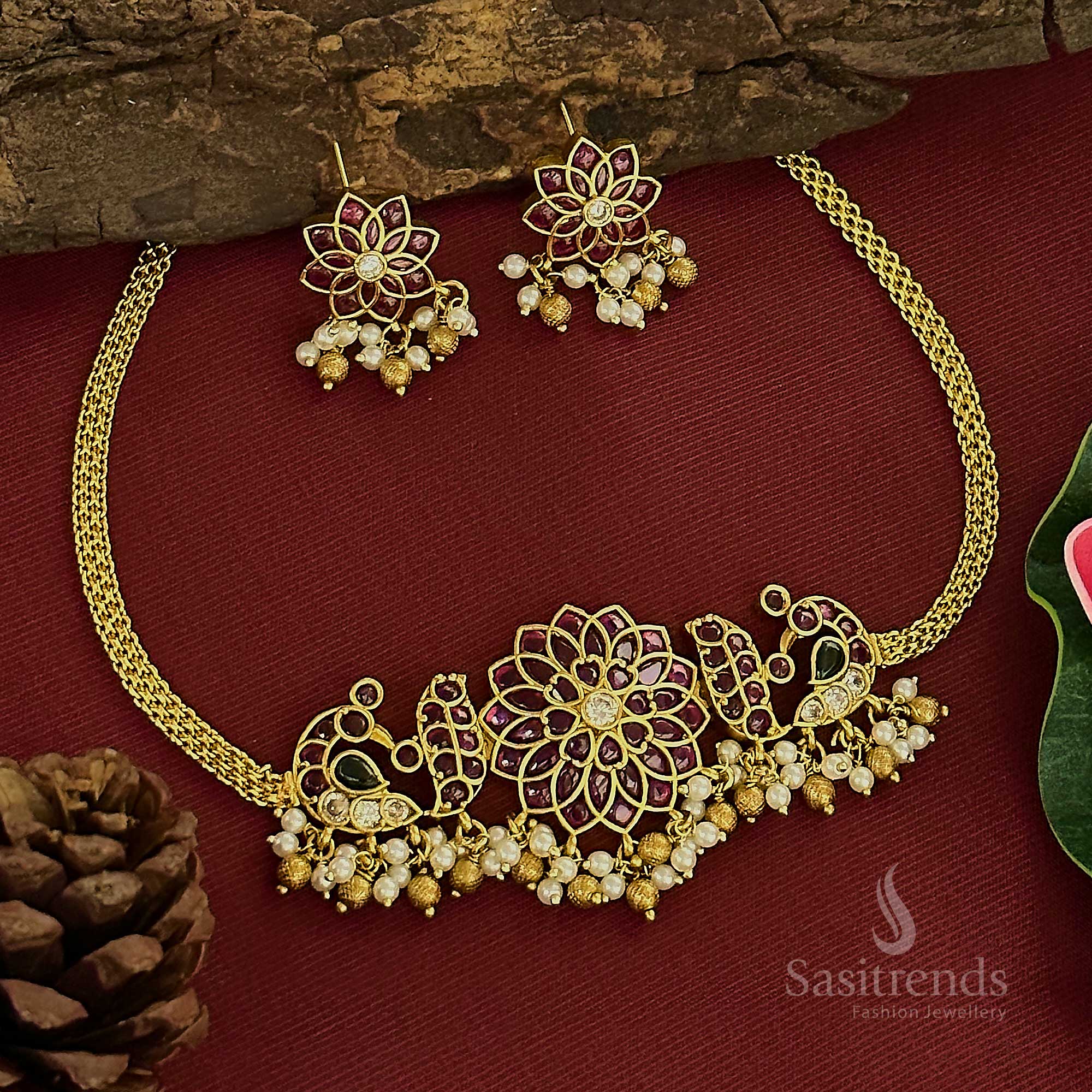 Trendy temple matte gold tone choker jewellery set featuring an ornate peacock and floral fusion design, embellished with glittering AD stones and pearl accents for a look of traditional grace – Sasitrends