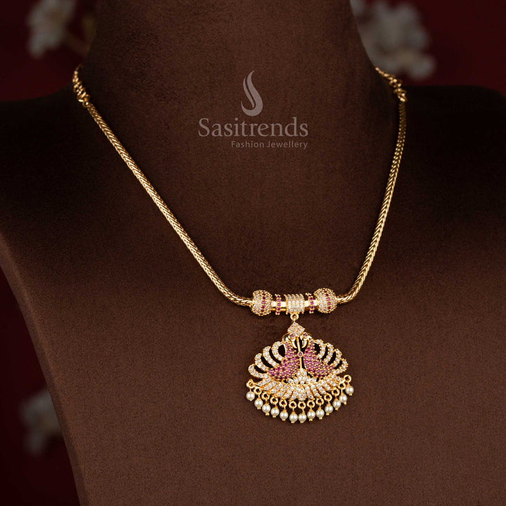Sasitrends micro gold plated pendant chain necklace designed with a temple-inspired dual peacock pendant structure highlighted by white AD stones and white ruby detailing, perfect for poojas and traditional silk sarees.