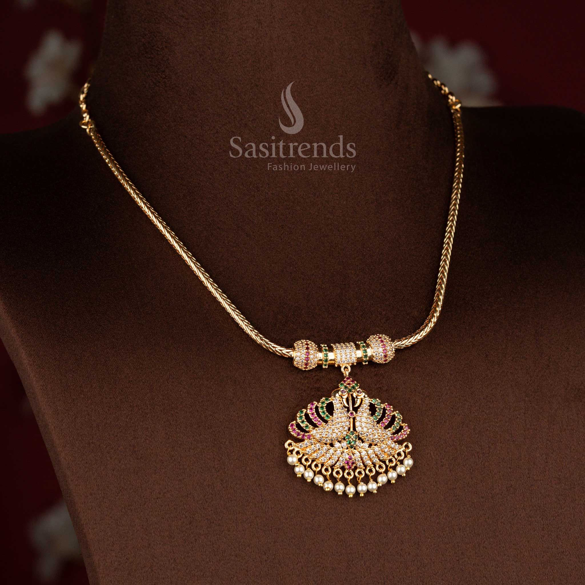 Sasitrends micro gold plated pendant chain necklace showcasing a temple-style dual peacock pendant structure with multi colour AD stone detailing and pearl fringe finish, best worn for poojas, special occasions, and classic silk sarees.