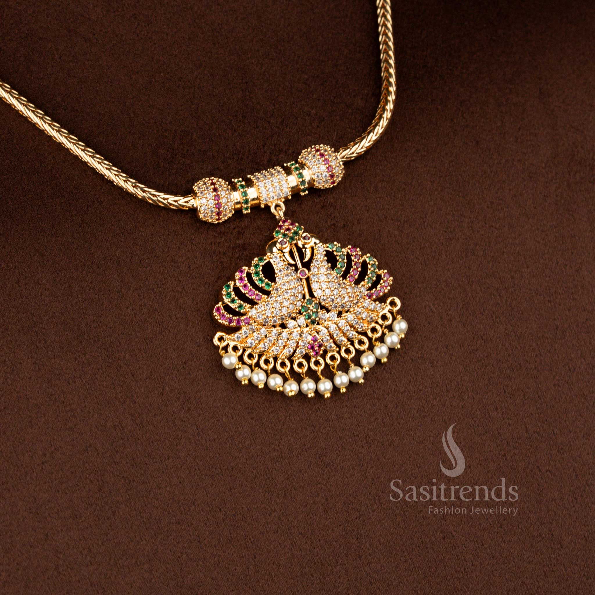 Sasitrends micro gold plated one gram pendant chain necklace featuring a dual peacock pendant structure embellished with multi colour AD stones and pearl drop accents, ideal for festive occasions and vibrant ethnic saree styling.