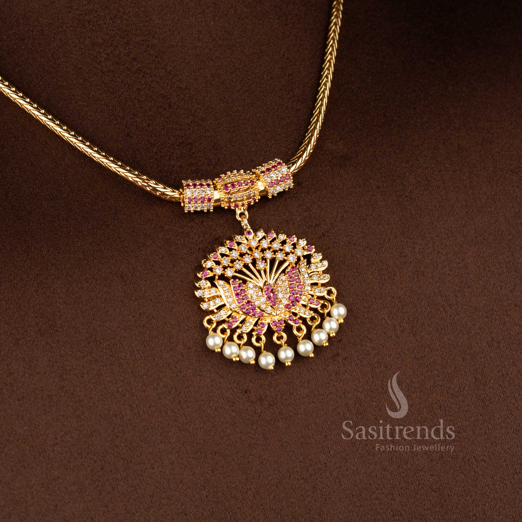 Sasitrends micro gold plated one gram pendant chain necklace crafted with a lotus motif pendant structure accented with white AD stones and white ruby highlights, finished with pearl drop detailing for a 24K real gold look.