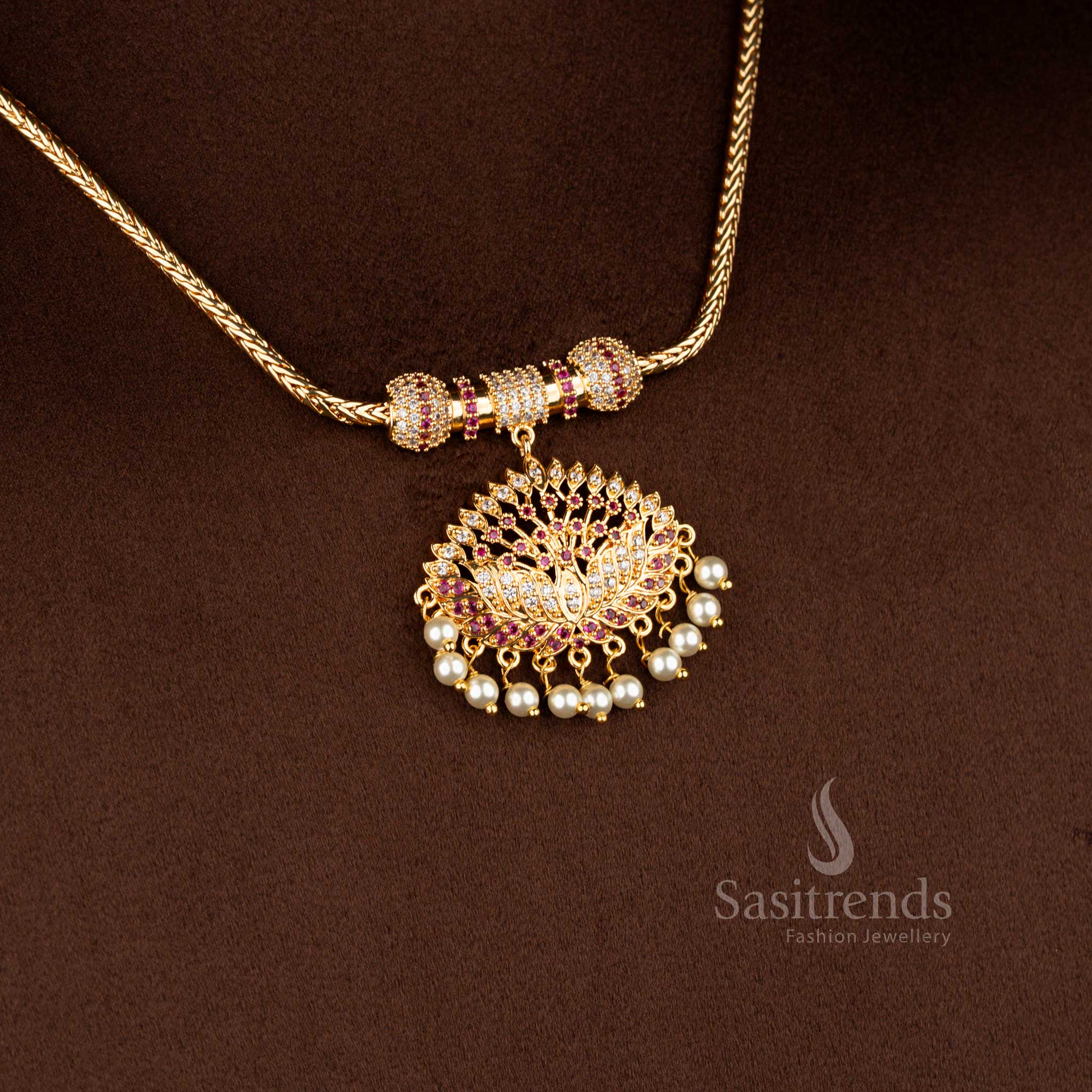 Sasitrends traditional pendant chain necklace featuring a sculpted lotus design pendant structure adorned with white AD stones and white ruby accents, bordered with pearl hangings and paired with a flexible gold-tone chain.