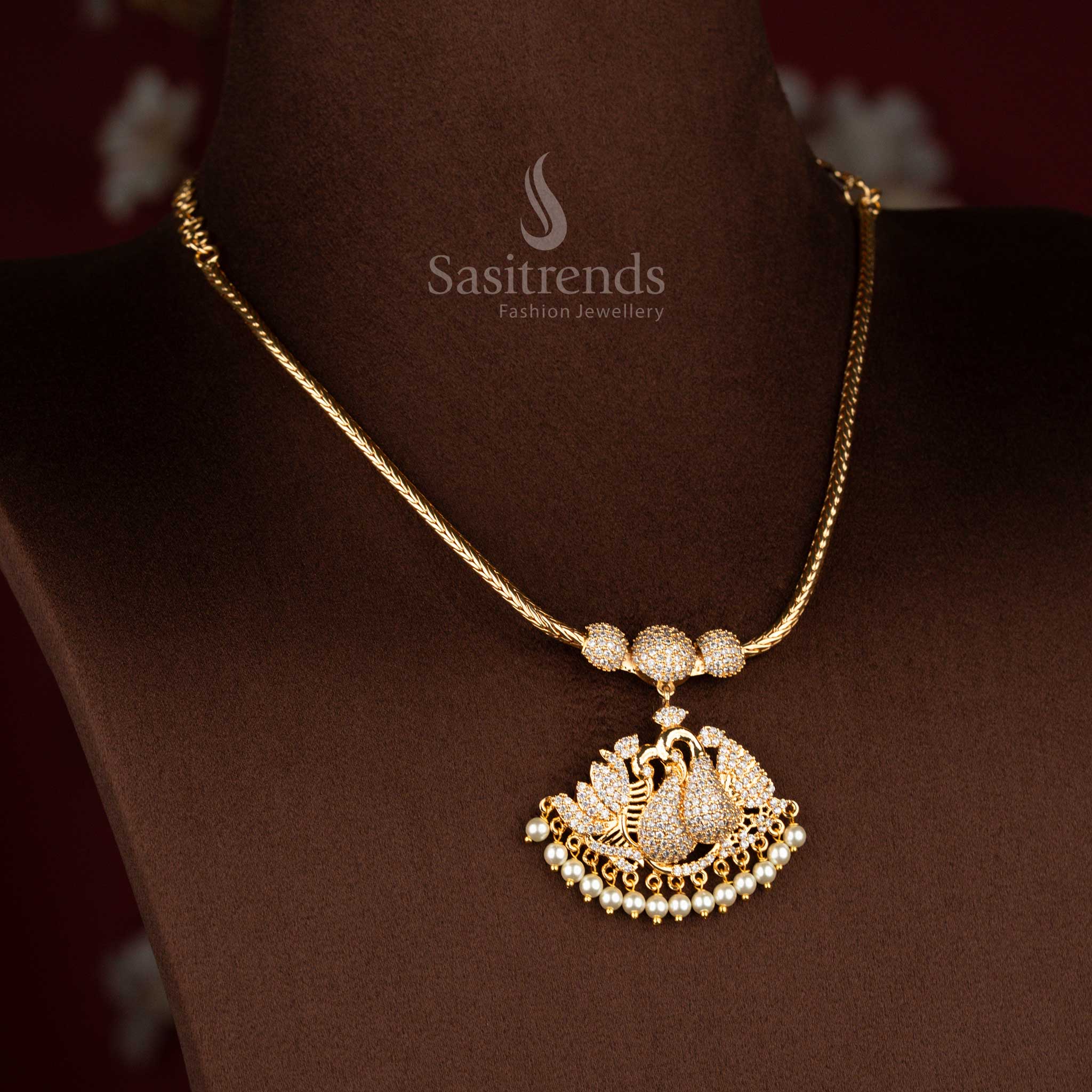 Sasitrends micro gold plated pendant chain necklace showcasing a temple-style single peacock pendant with detailed white AD stone setting and pearl hangings, perfect for traditional ceremonies and ethnic occasions.