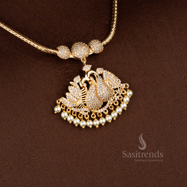 Sasitrends micro gold plated one gram pendant chain necklace featuring a single peacock pendant structure with paisley-style feather detailing, set in white AD stones and finished with pearl drops, ideal for temple wear, poojas, and traditional silk sarees.