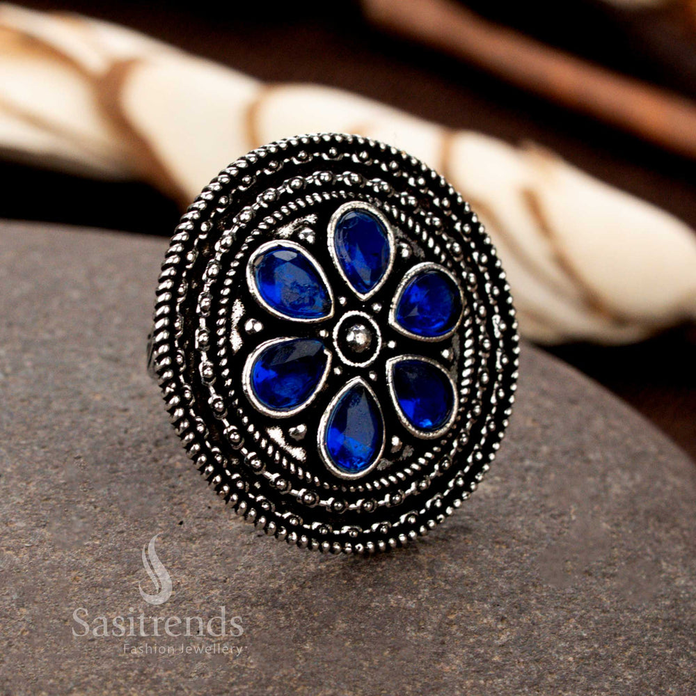 A heritage oxidised silver adjustable ring with finely sculpted floral motifs and a mesmerizing blue stone, blending antiquity with modern beauty - Sasitrends