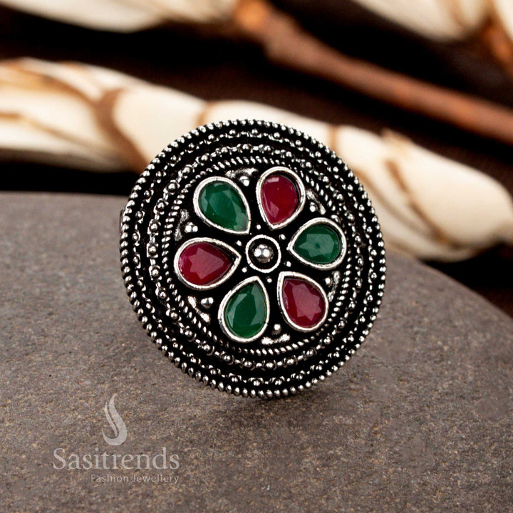   A classic oxidised floral adjustable ring with masterfully handcrafted petal motifs, adorned with a striking ruby-green gemstone duo for a festive touch - Sasitrends