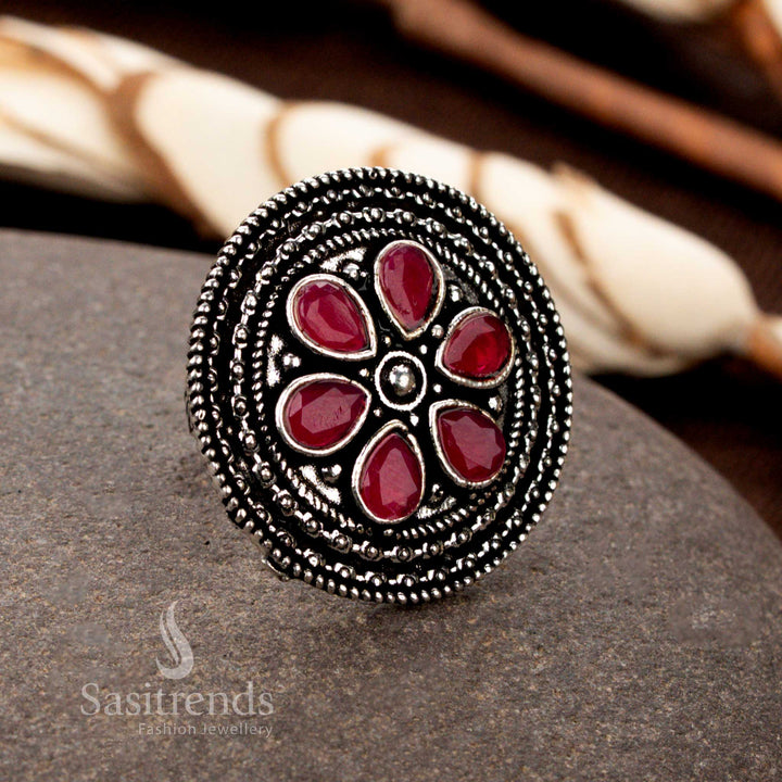 An exquisite oxidised adjustable floral stone ring featuring fine petal carvings and a radiant ruby gemstone, offering a regal charm to traditional jewellery collections - Sasitrends