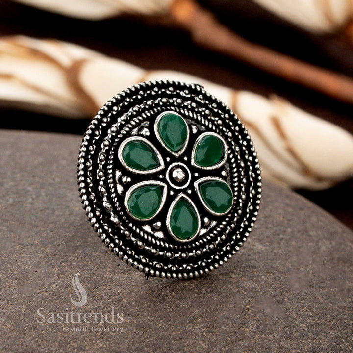 A stunning oxidised adjustable floral ring featuring intricate petal designs and a lush green gemstone, bringing a fresh and vibrant touch to traditional outfits - Sasitrends