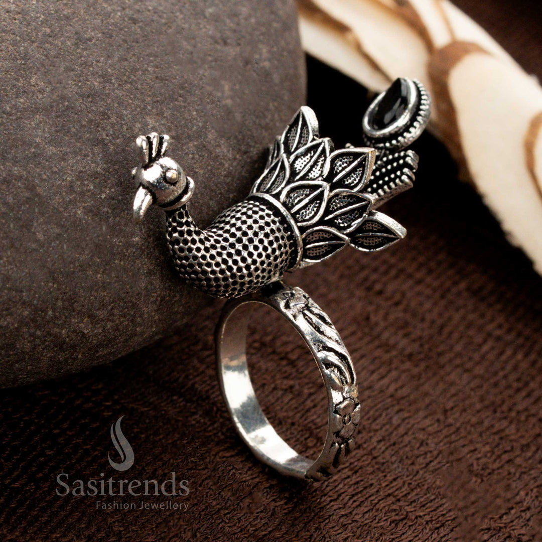 An antique-finish oxidised peacock adjustable ring with intricate feather engravings, showcasing a deep black stone that enhances its regal and vintage appeal - Sasitrends