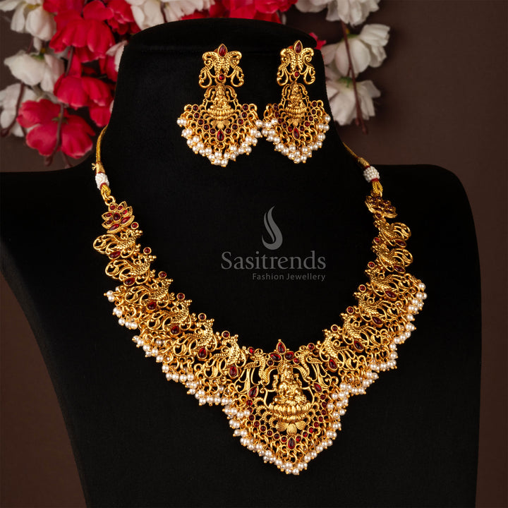 Artistic matte gold temple necklace jewellery set featuring divine Lakshmi motif with peacock embellishments and dazzling ruby stones - Sasitrends