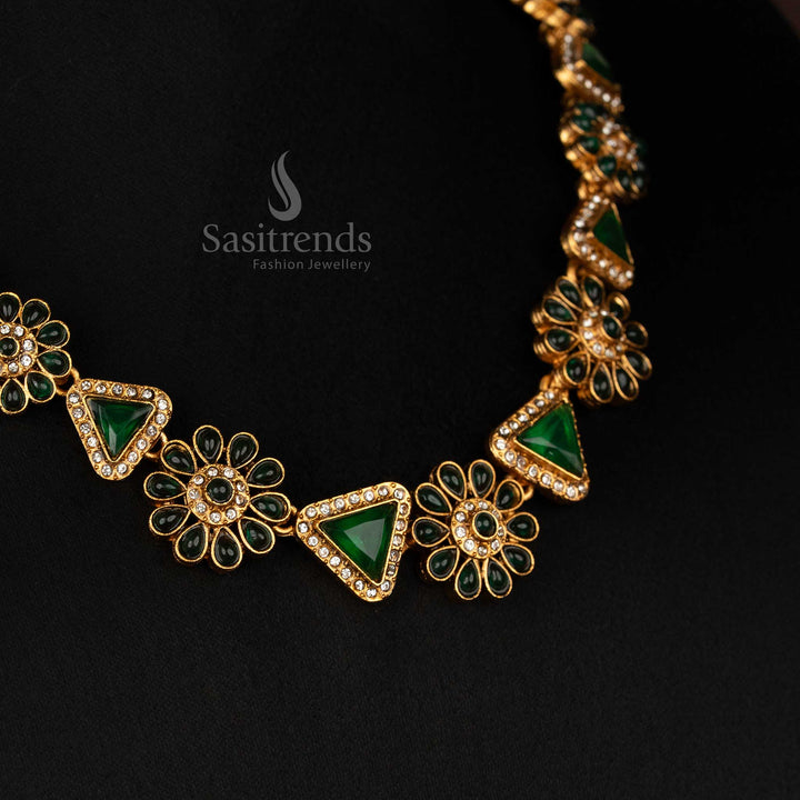 Close-up of the Classic Matte Gold Plated Green necklace, highlighting its intricate floral, triangular design and sparkling stones.
