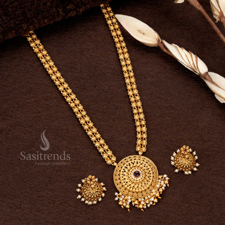 Classic temple matte gold-plated long haram with circular filigree pendant, ruby-green stones, and pearl hangings - Sasitrends
