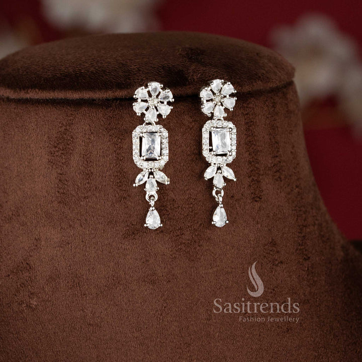 Elegant white American Diamond drop earrings with a floral stud and a rectangular stone centerpiece in a rhodium silver finish - Sasitrends