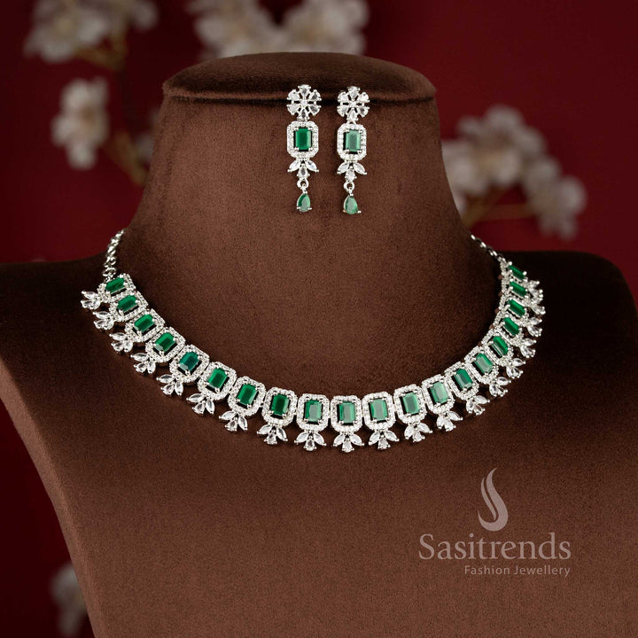 Elegant green American Diamond drop earrings with a floral stud and a rectangular emerald-green stone centerpiece in a rhodium silver finish - Sasitrends