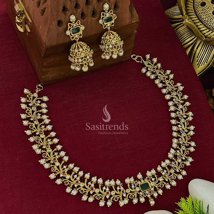 Elegant matte gold plated temple choker jewellery set with graceful floral design and a luminous centre green stone, paired with heritage-style jhumkas – Sasitrends