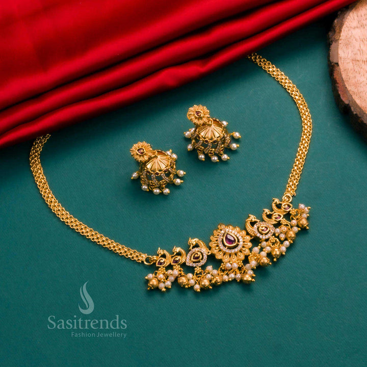 Beautifully crafted matte gold choker with ruby-white dual tone and peacock centrepiece, adorned with AD stones and jhumka earrings – for traditional saree styling – Sasitrends