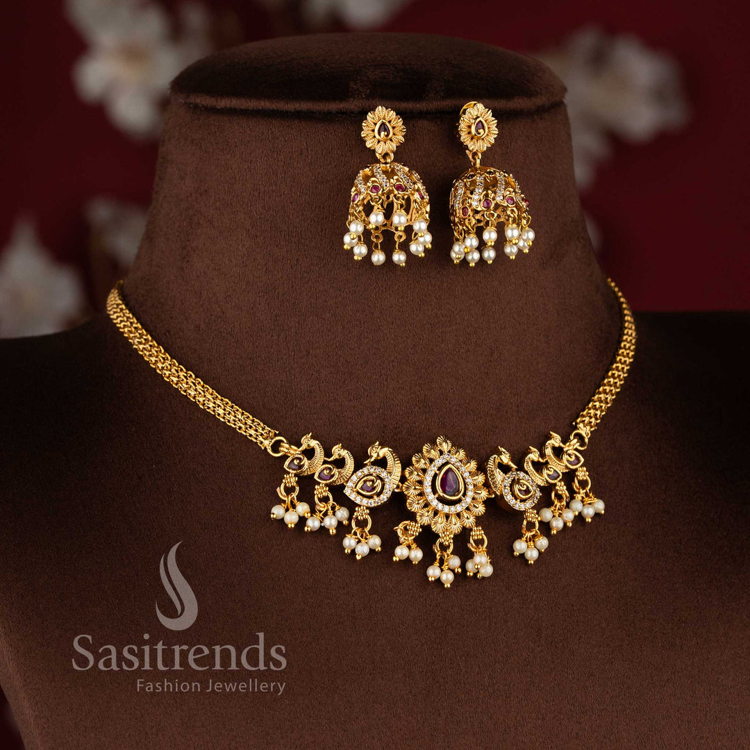  Traditional matte gold plated peacock choker necklace set with jhumkas and AD stones in ruby white by Sasitrends.
