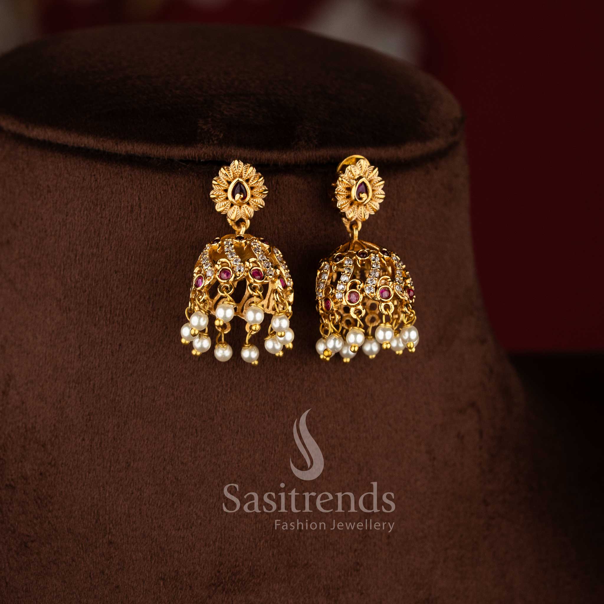 Elegant temple matte gold peacock choker set with ruby and white stones and matching jhumkas.