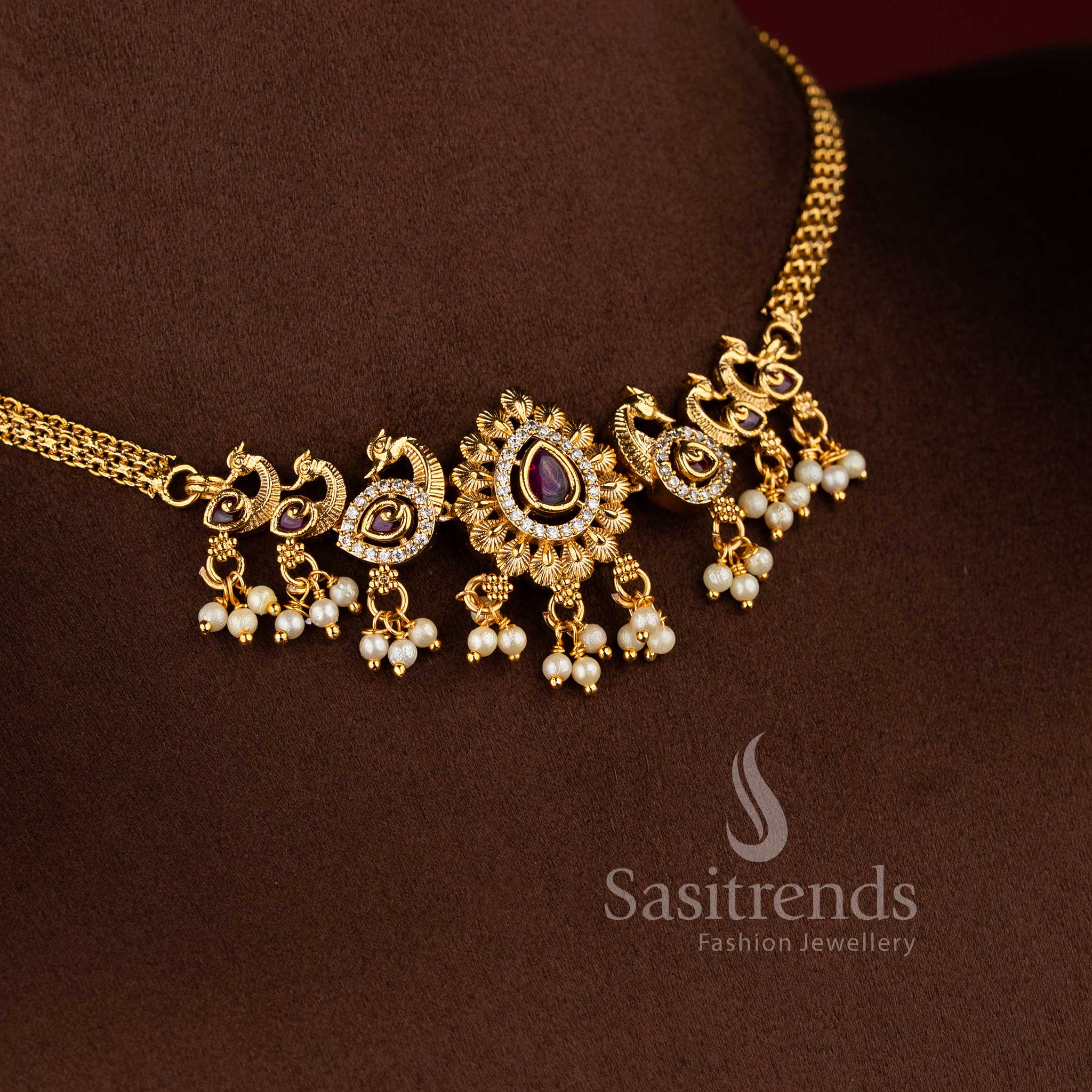  Traditional matte gold plated peacock choker necklace set with jhumkas and AD stones in ruby white by Sasitrends.
