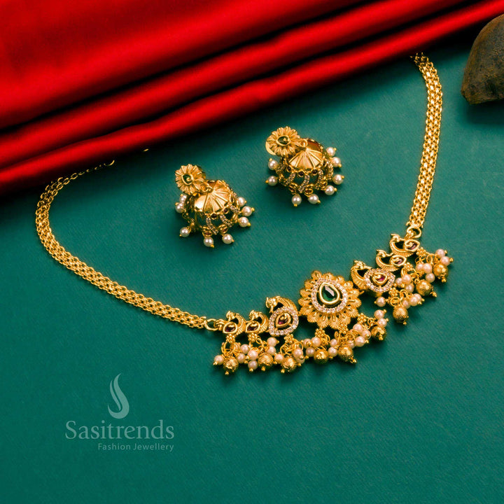 A vibrant peacock choker in multi-shaded stones, matte gold plating, and American diamonds, complete with handcrafted jhumkas – a festive delight – Sasitrends