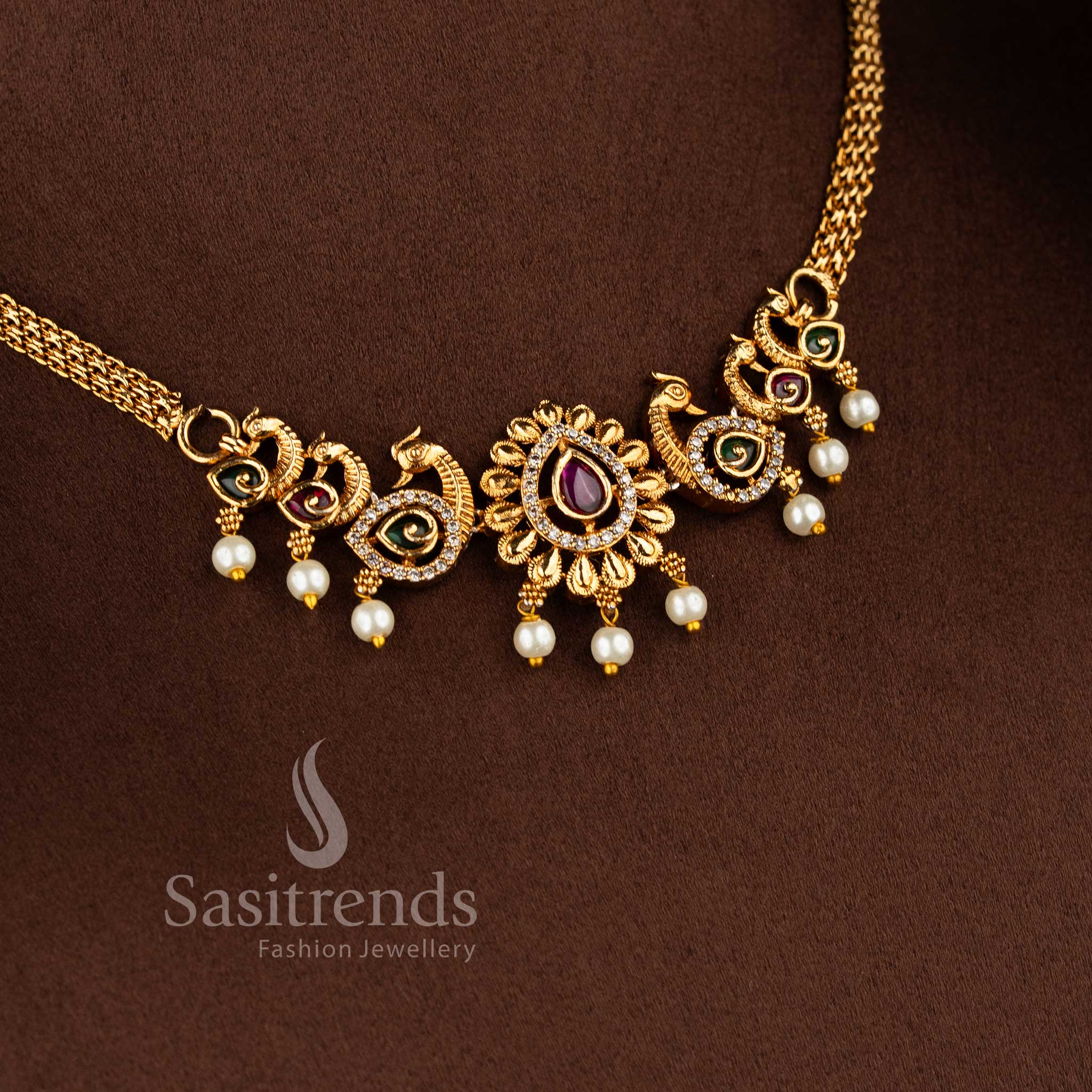 Traditional matte gold plated peacock choker necklace set with jhumkas and AD stones in ruby green by Sasitrends.