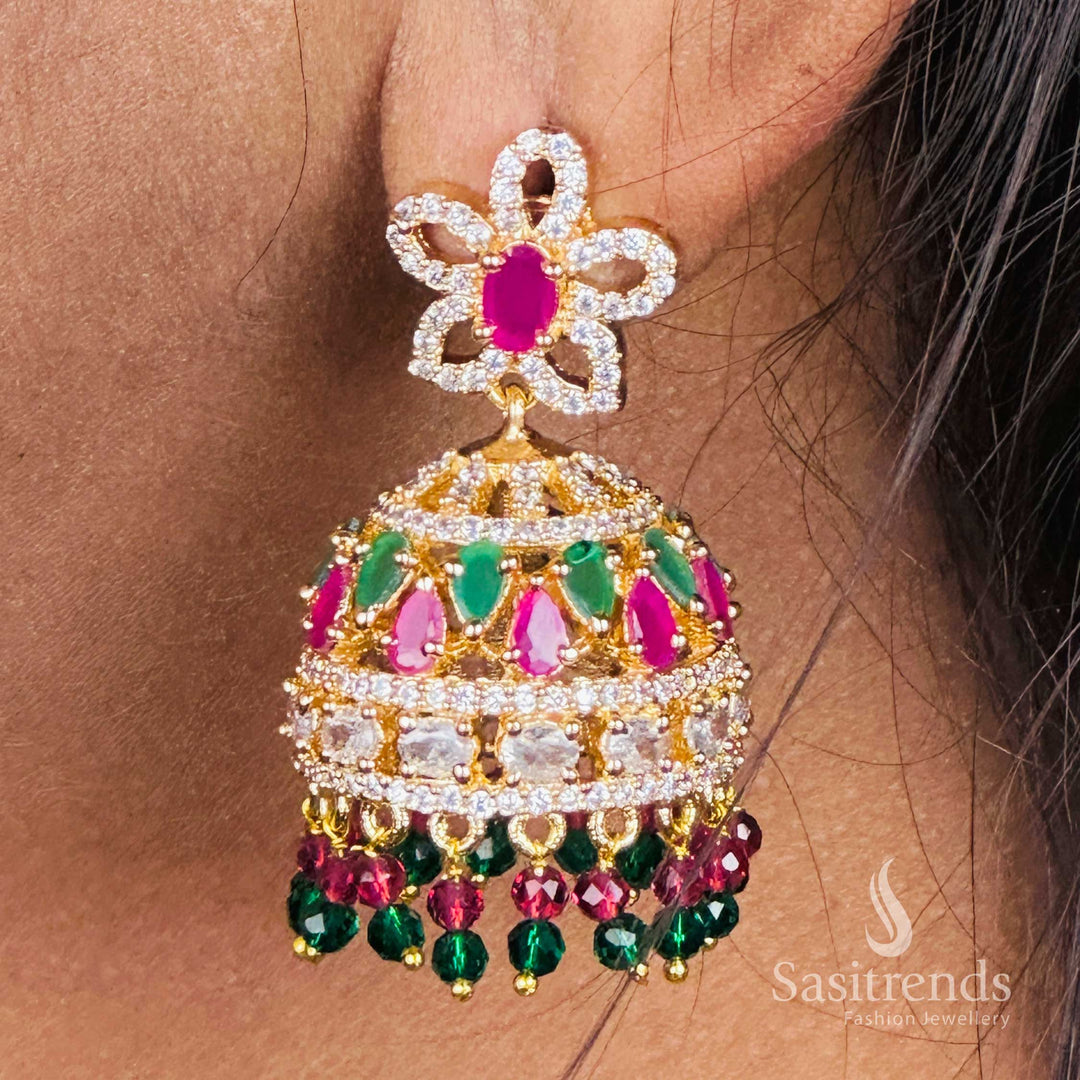 Trendy gold plated floral stud top jhumka earrings adorned with sparkling American Diamond stones – An ethnic elegance and fusion-style designer jewellery piece – Sasitrends
