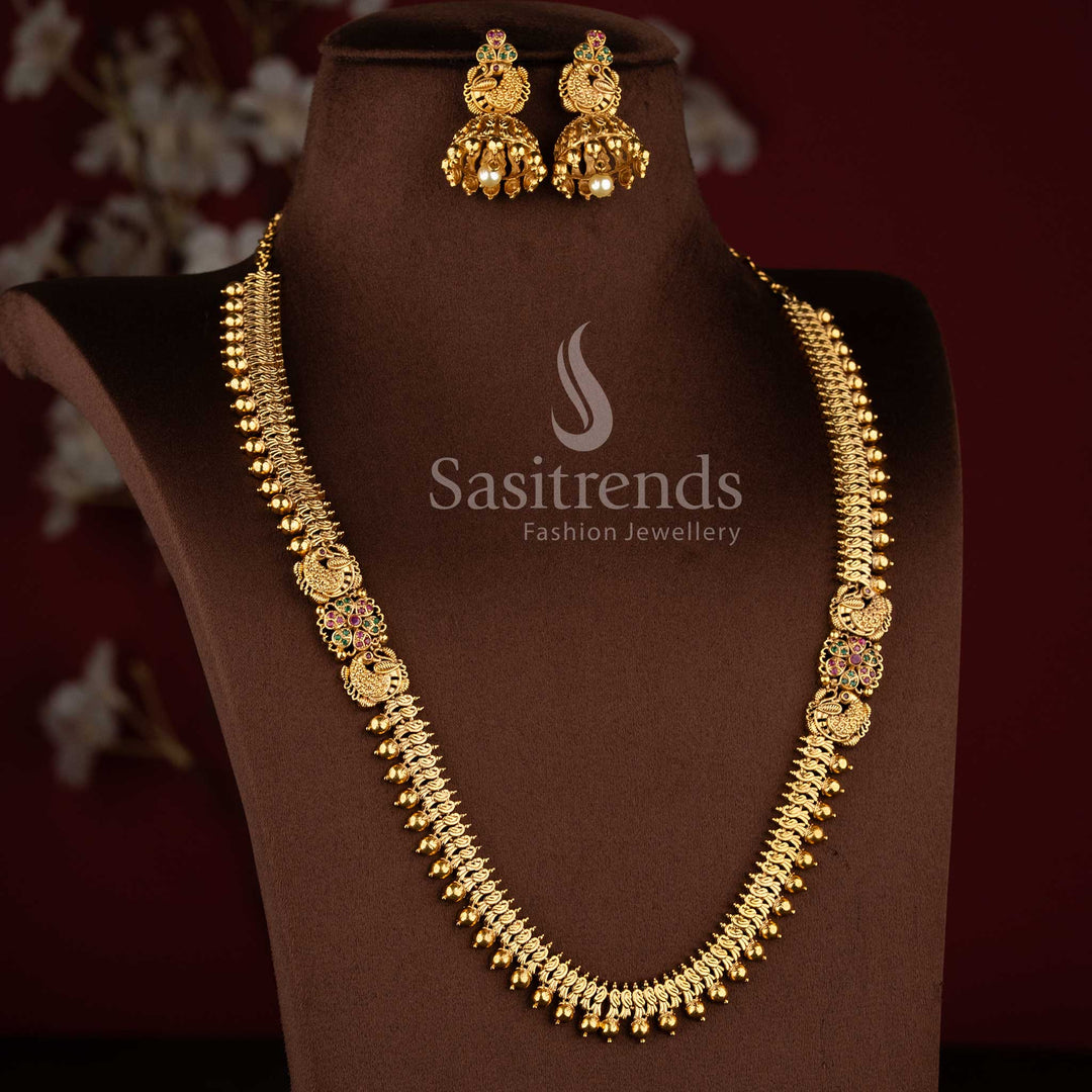 Bridal matte gold peacock design long necklace set with AD stones and jhumkas in ruby green combination.