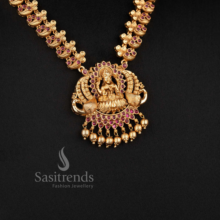 Traditional Nakshi style temple jewellery set with Lakshmi peacock haram necklace in ruby color and matching jhumkas in matte gold tone by Sasitrends