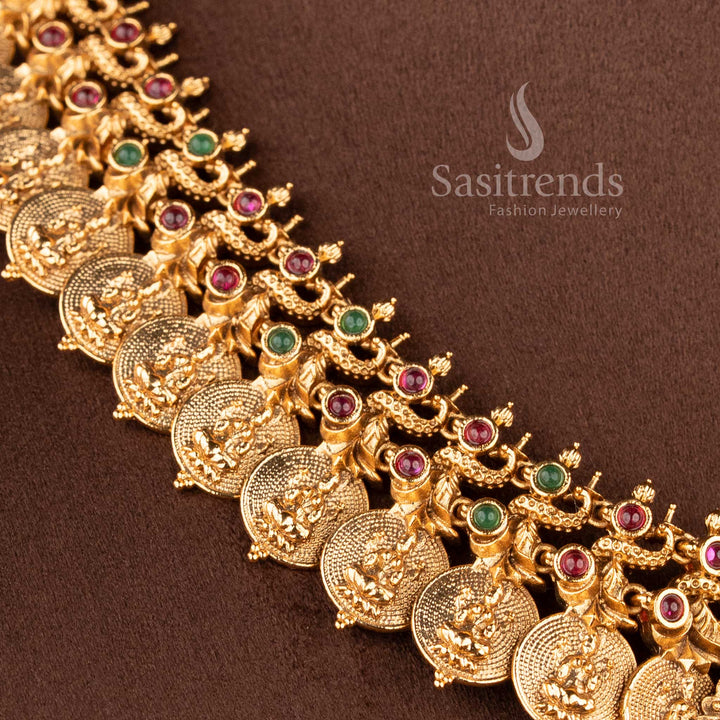Elegant South Indian bridal temple jewellery set featuring Lakshmi peacock haram necklace in matte gold finish with ruby green stones and matching jhumkas by Sasitrends