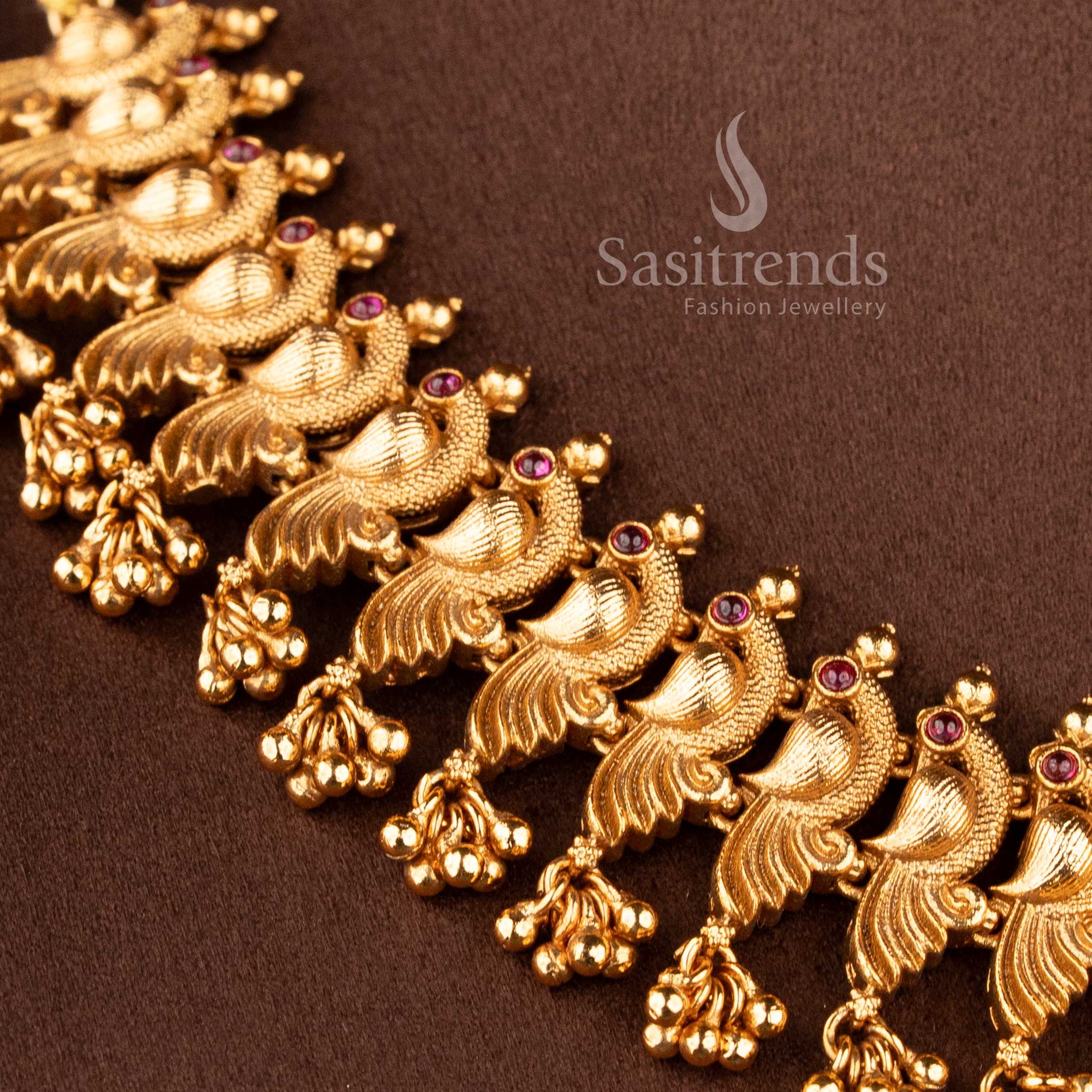 Matching peacock-stud jhumkas with ruby-encrusted domes and gold bead drops from the temple jewellery for wedding collection - Sasitrends