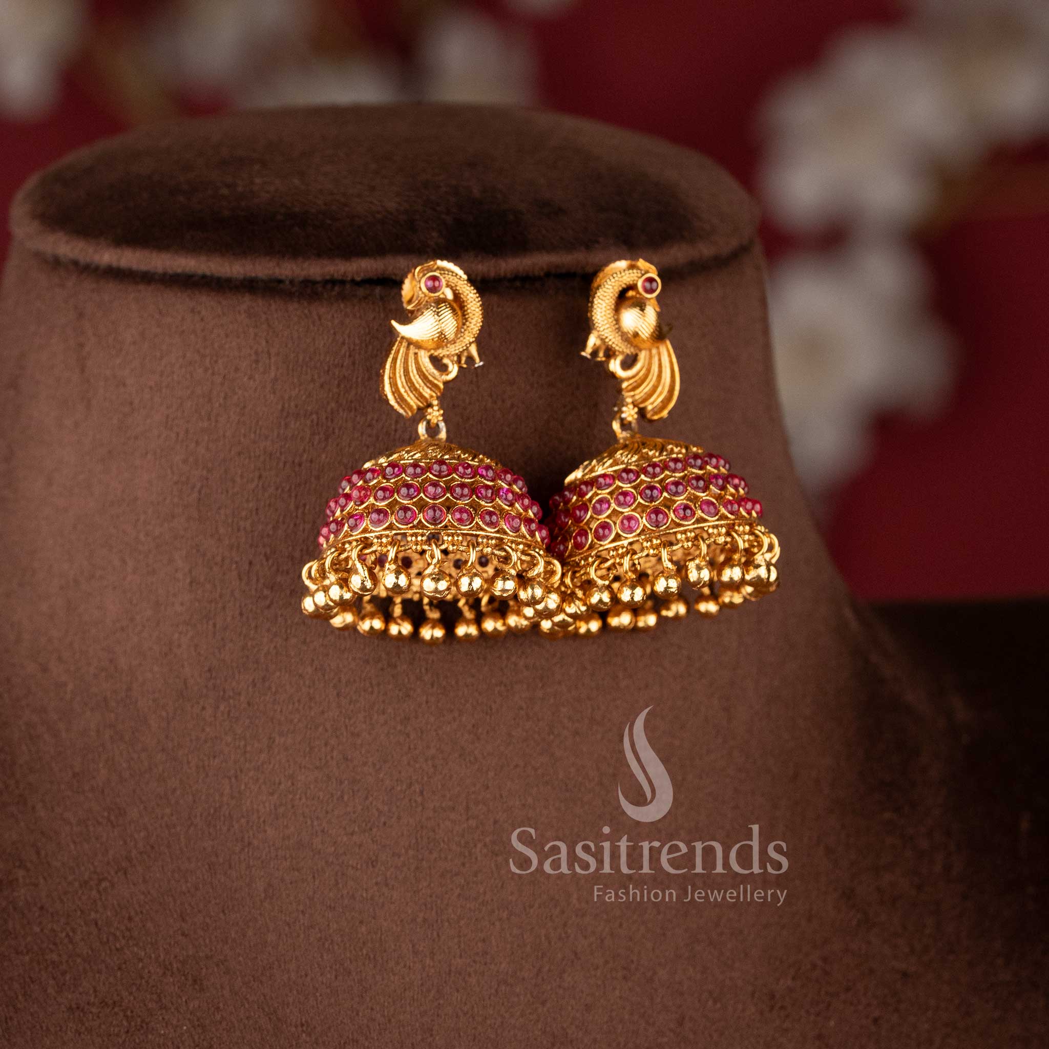 Matching peacock-stud jhumkas with ruby-encrusted domes and gold bead drops from the temple jewellery for wedding collection - Sasitrends