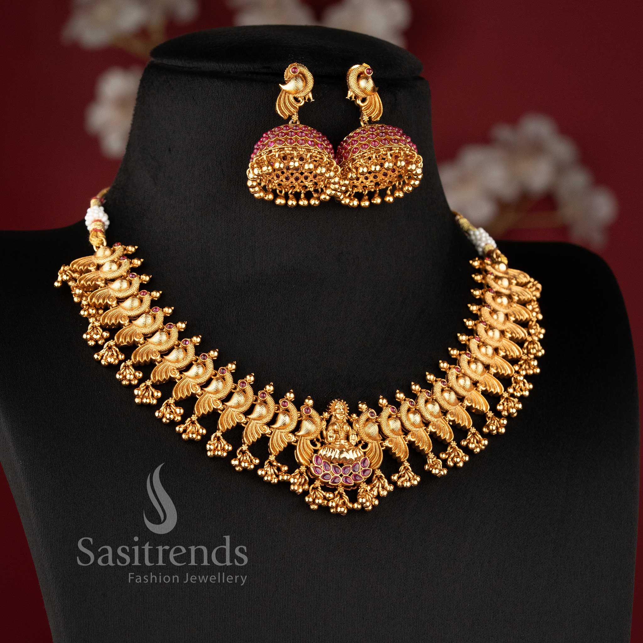 Matching peacock-stud jhumkas with ruby-encrusted domes and gold bead drops from the temple jewellery for wedding collection - Sasitrends