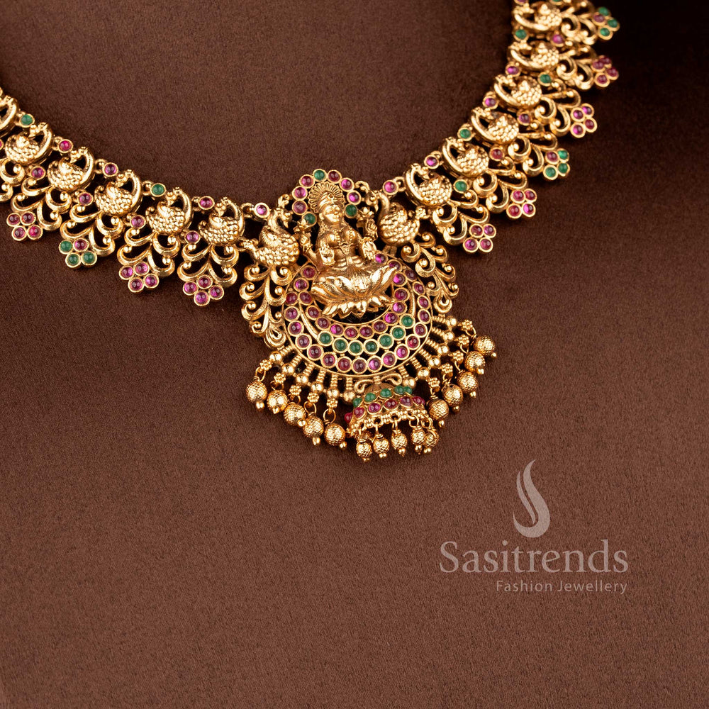 Grand Temple Jewellery Set for brides featuring a seated Lakshmi pendant with a unique mini-jhumka drop and peacock cluster links - Sasitrends