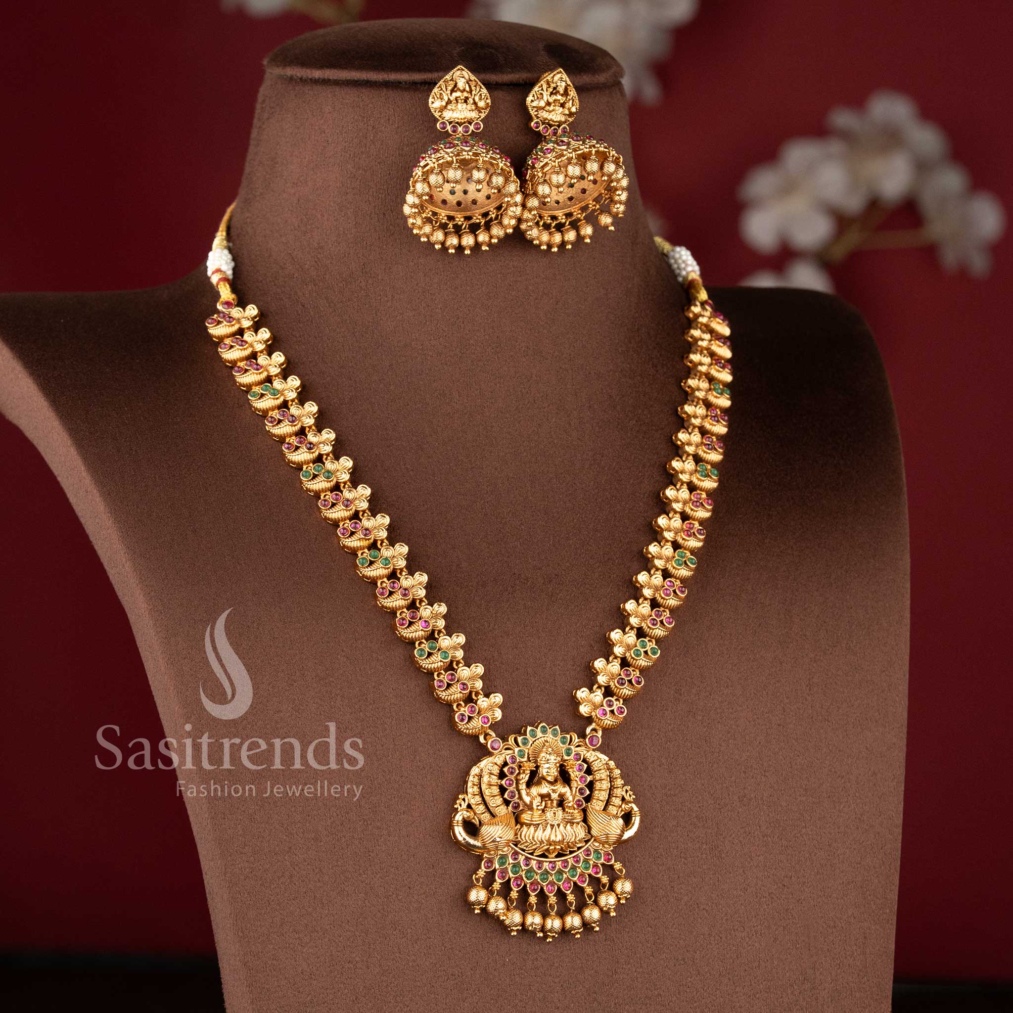 Grand bridal temple jewellery set featuring Lakshmi peacock haram necklace in ruby green finish with matching jhumkas, ideal for saree and lehenga by Sasitrends