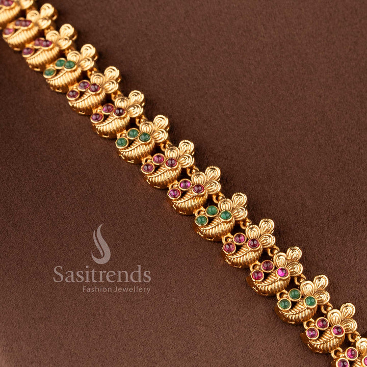 Elegant South Indian bridal temple jewellery set featuring Lakshmi peacock haram necklace in matte gold finish with ruby green stones and matching jhumkas by Sasitrends
