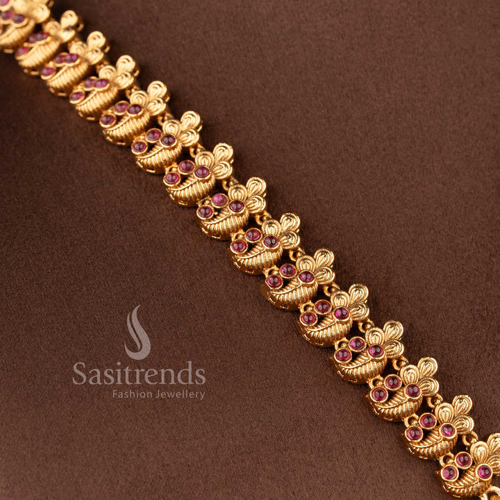 Traditional bridal wear temple matte gold tone Lakshmi and peacock haram necklace jewellery set in ruby color with matching jhumkas by Sasitrends, perfect for wedding and festive occasions