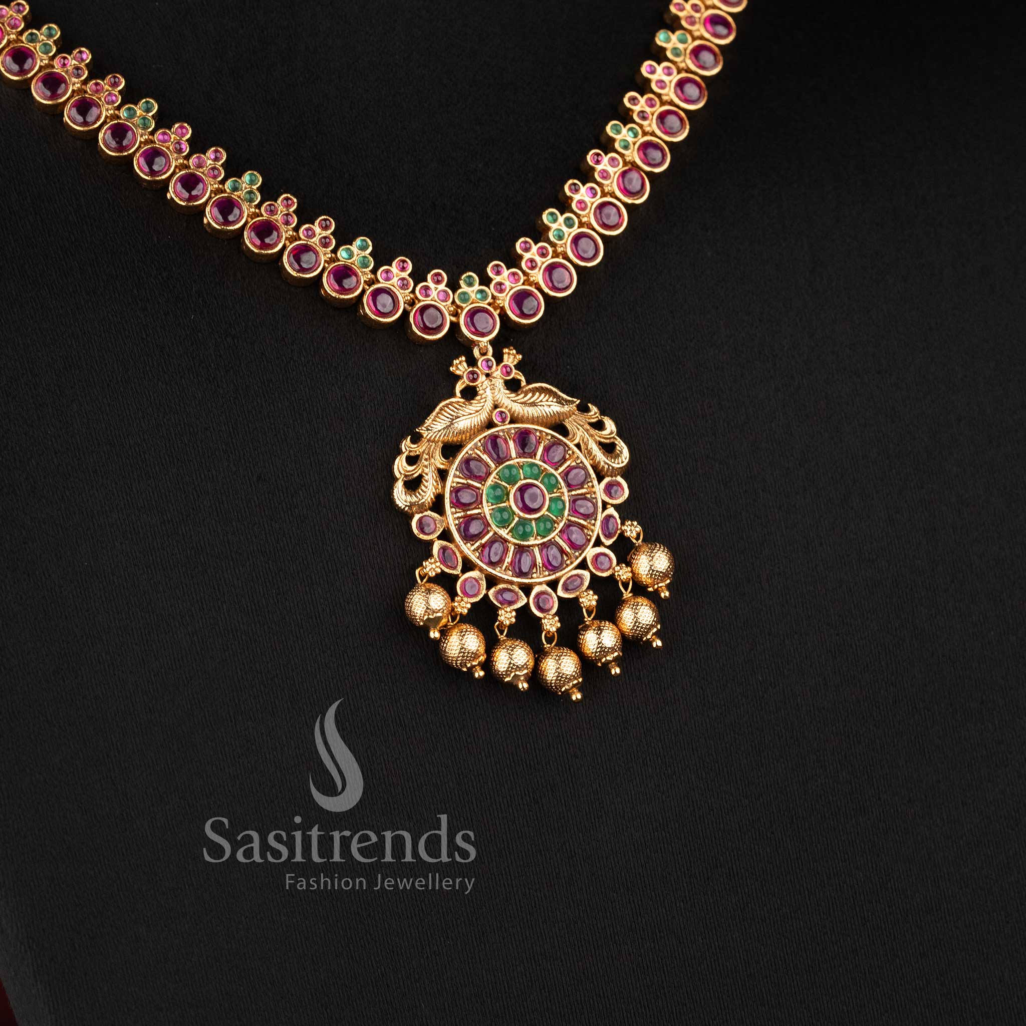 Elegant South Indian bridal temple jewellery set featuring ruby Kemp peacock necklace in matte gold finish by Sasitrends for traditional wear