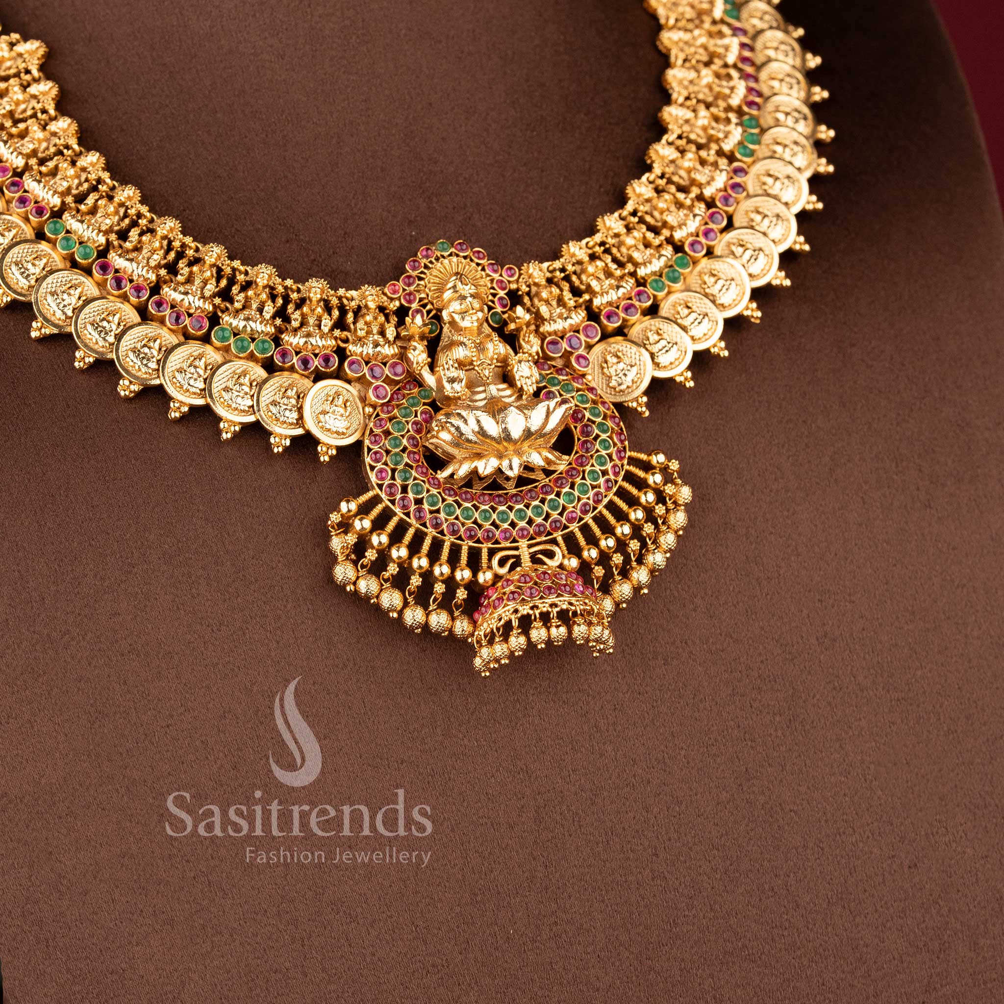 Traditional temple jewellery necklace set with Lakshmi lotus and kasu design in ruby green color and matte gold tone by Sasitrends for bridal wear