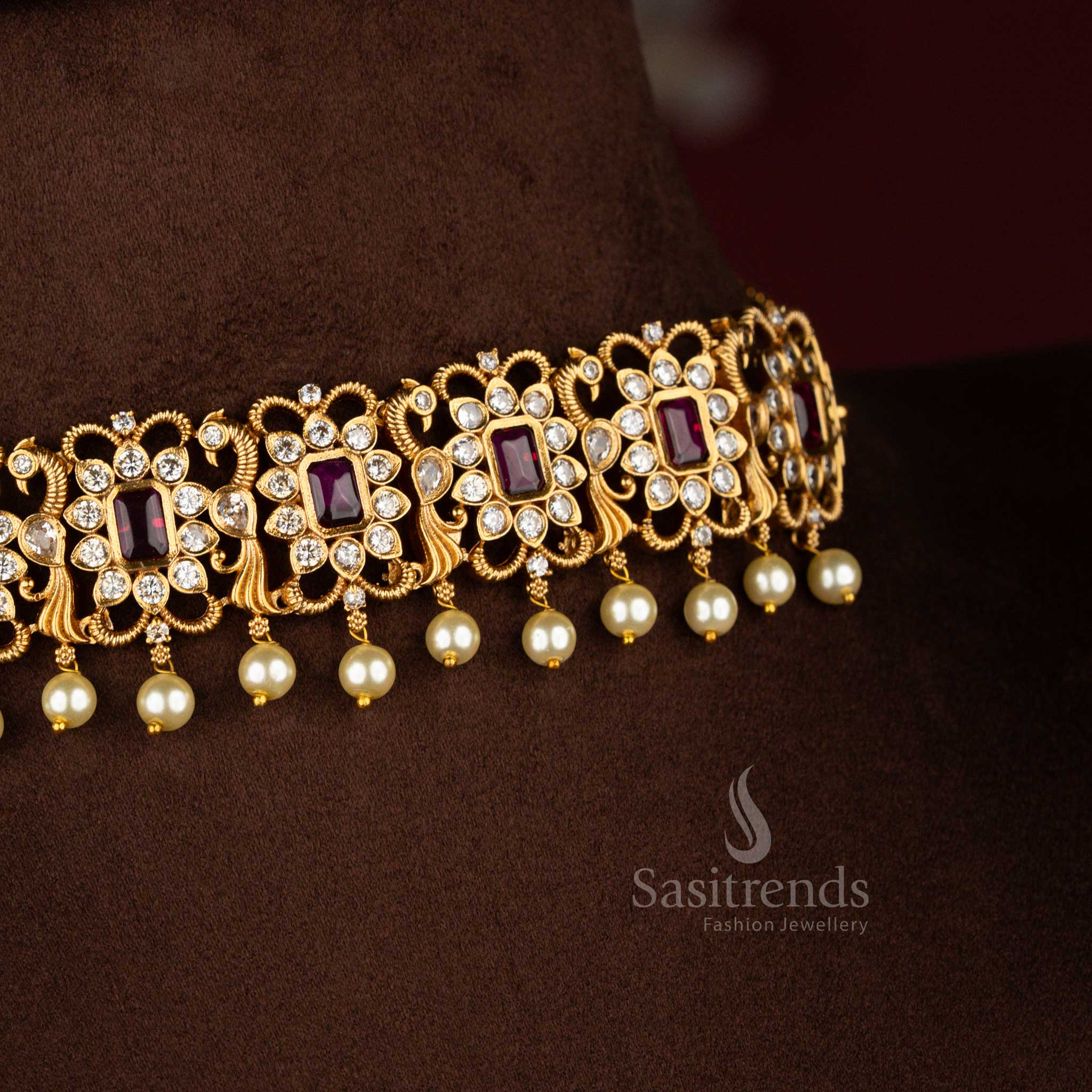 Elegant ruby temple choker jewellery set adorned with a graceful peacock motif, designer matte gold finish, and shimmering AD accents for traditional women – Sasitrends