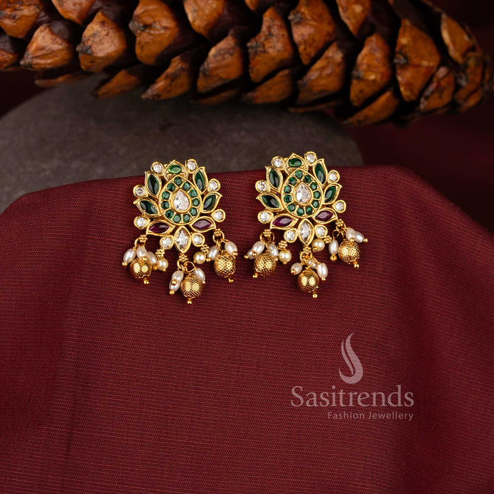 Multi-hue Kemp AD stone lotus earrings with a temple matte gold finish, showcasing ruby and vibrant tones with pearl-bead details for a bold and bright bridal jewellery statement – sasitrends