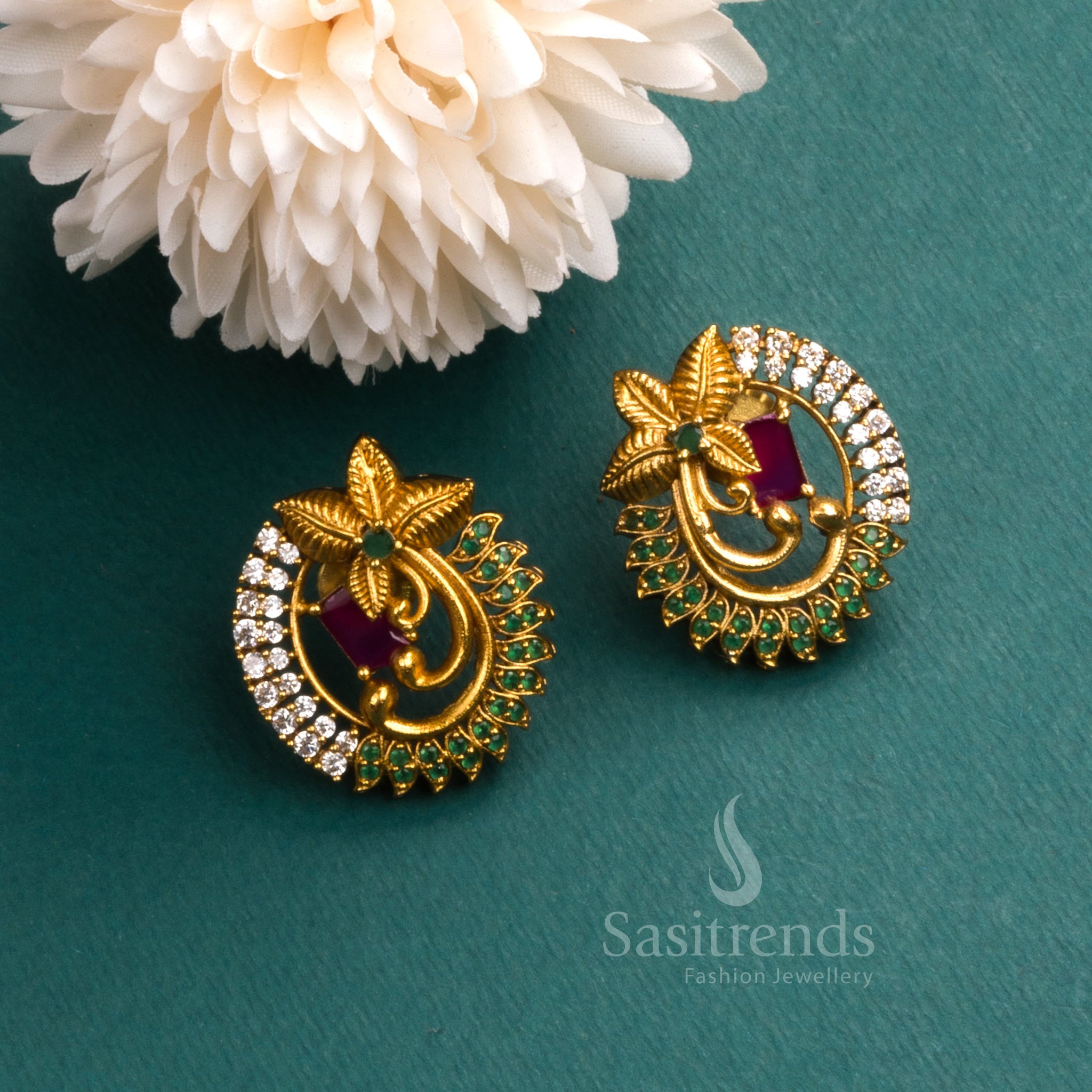Trendy temple matte gold tone floral earrings adorned with sparkling AD stones and rich ruby tone accents, exuding traditional jewellery elegance for festive occasions - Sasitrends