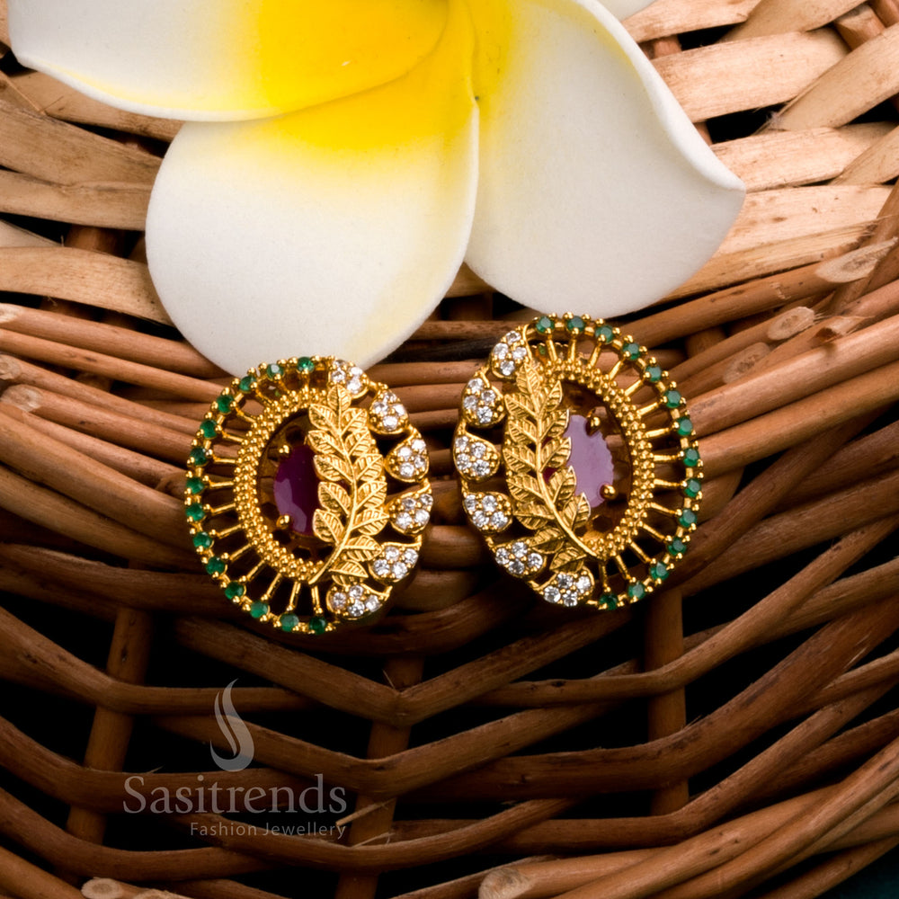 Elegant ruby-hued leaf motif earrings in temple matte gold finish, adorned with sparkling AD stones for a refined and classic jewellery attire - Sasitrends