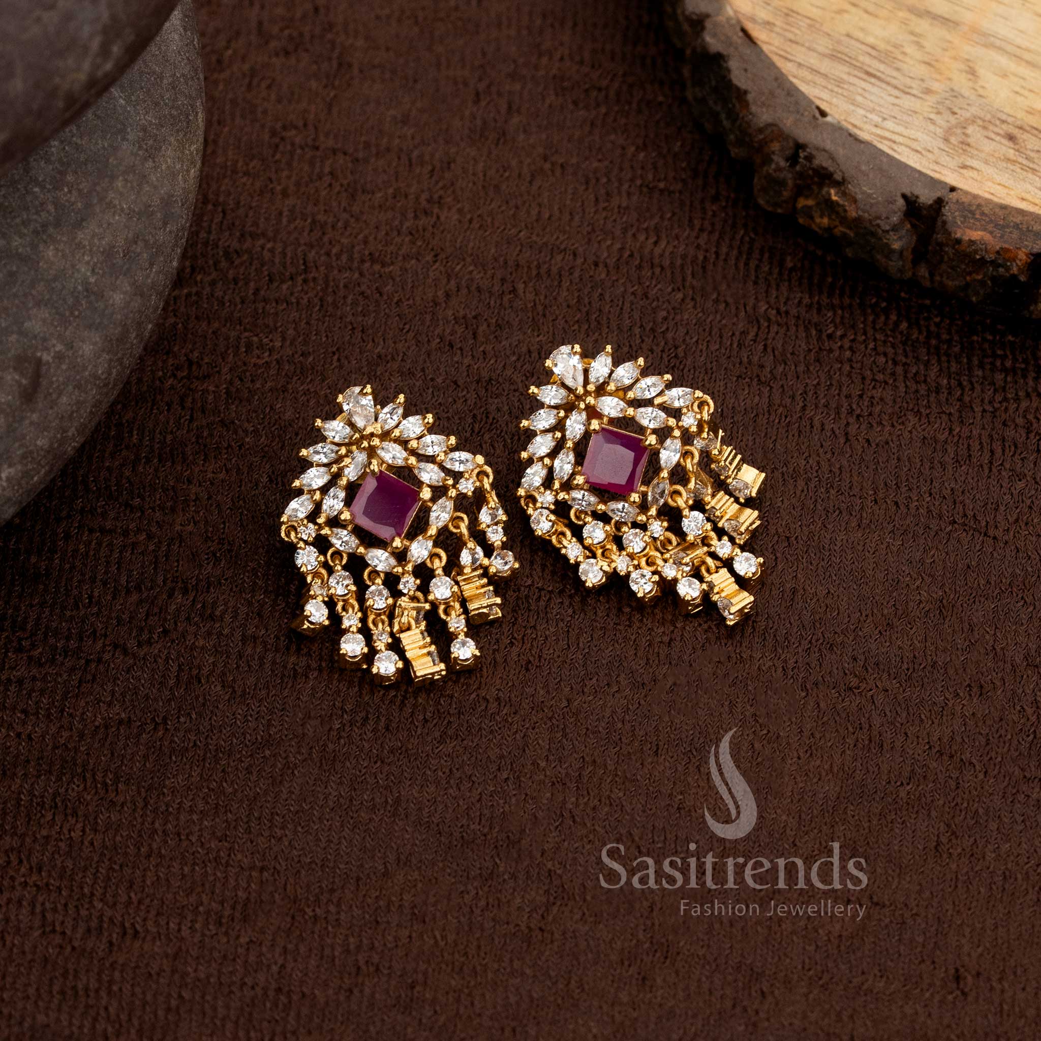 Stylish matte gold plated floral and geometric stud earrings adorned with white and ruby American diamonds finished with a cascading dangler design – Sasitrends