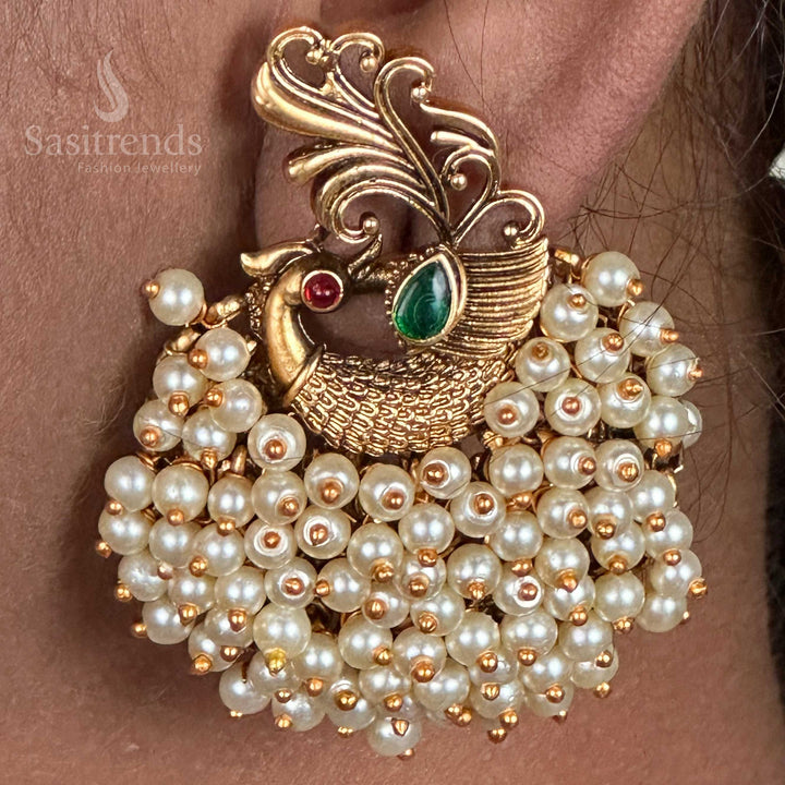 Divine temple-inspired peacock bunch earrings crafted in a matte gold finish, adorned with ethnic elements and a fine artisan touch, perfect for regal jewellery lovers seeking traditional charm – sasitrends