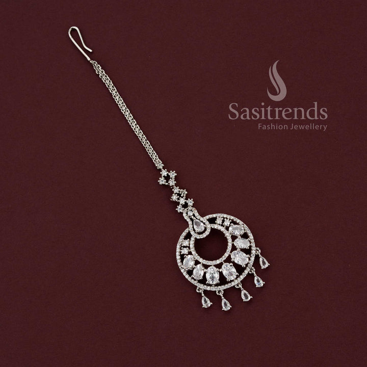 Elegant rhodium silver plated Maang Tikka featuring American Diamond circular motif with dangling pear-shaped drops, style 2129B by Sasitrends