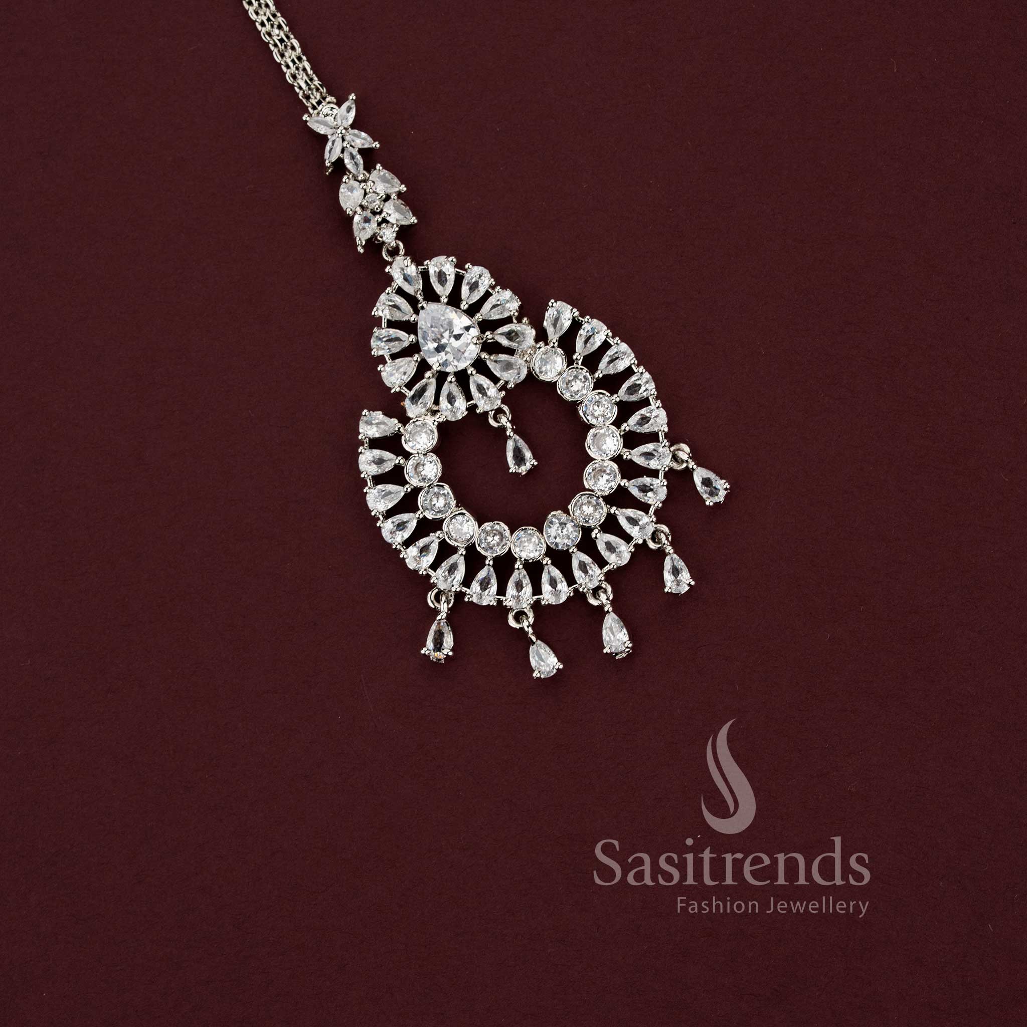 Intricate bridal rhodium silver maang tikka featuring a tiered floral teardrop design with brilliant American Diamond stones, perfect for engagement or wedding lehengas - Sasitrends