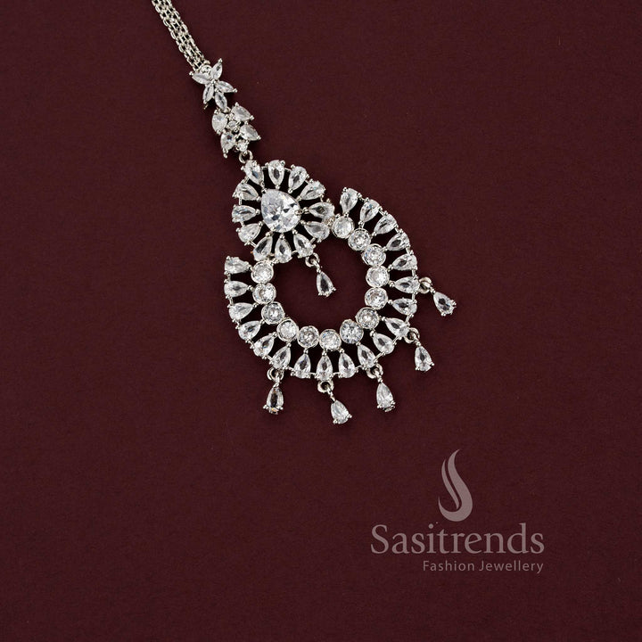 Intricate bridal rhodium silver maang tikka featuring a tiered floral teardrop design with brilliant American Diamond stones, perfect for engagement or wedding lehengas - Sasitrends